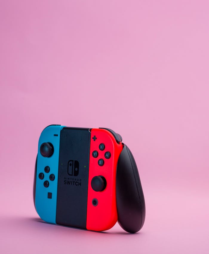 Vibrant Nintendo Switch controller displayed against a pink backdrop, highlighting modern gaming aesthetics.